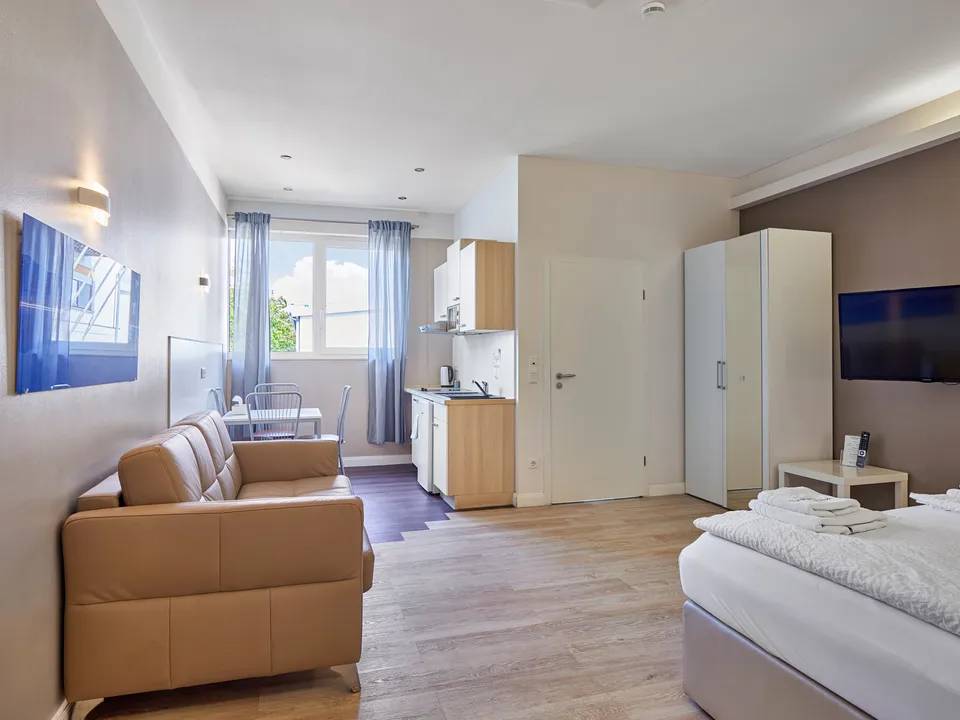 Wohnbereich eines Studio-Apartments mit Sofa und Tisch